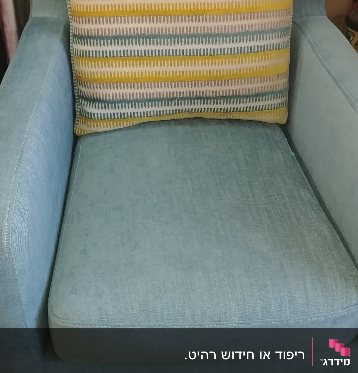 כרית פסים צבעונית על כורסה מרופדת כחולה